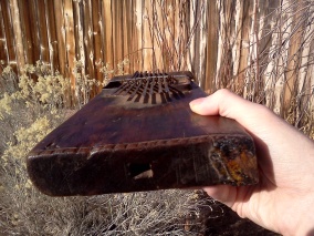 View from below of antique kalimba, showing hole cut in hollow body